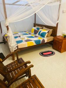 une chambre avec un lit et une chaise dans l'établissement Kawi Holiday Home, à Batigama 20 autres photos