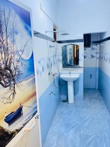 une salle de bains avec un lavabo et des toilettes avec un tableau dans l'établissement Kawi Holiday Home, à Batigama