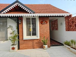 una casa de ladrillo con dos macetas delante de ella en Suseelagam, en Sīrkāzhi 17 fotos más