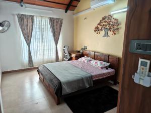 un dormitorio con una cama y una ventana en Suseelagam, en Sīrkāzhi