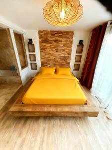 a large yellow bed in a bedroom with a chandelier at Villa Le M in Six-Fours-les-Plages +29 photos