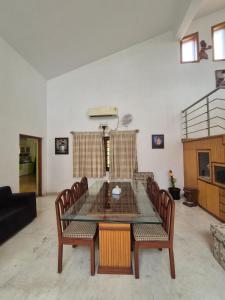 a living room with a glass table and chairs at Charu's Villa By Elite Stays in Jāmb