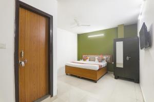 a bedroom with a bed and a wooden door at FabHotel Raas Inn in Lucknow