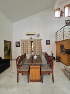 a dining room with a glass table and chairs at Charu's Villa By Elite Stays in Jāmb