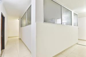 a hallway with white walls and glass windows at FabHotel Raas Inn in Lucknow