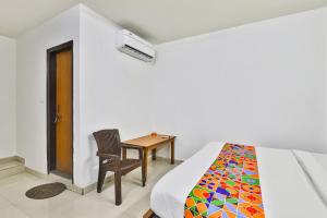 a bedroom with a bed and a chair and a table at FabHotel Raas Inn in Lucknow +15 photos