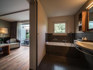 a bathroom with a tub and a sink at Royal St. Georges Hotel Interlaken - MGallery Collection in Interlaken