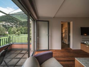 a living room with a couch and a balcony at Royal St. Georges Hotel Interlaken - MGallery Collection in Interlaken