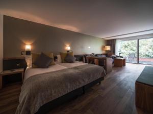 a hotel room with a bed and a large window at Royal St. Georges Hotel Interlaken - MGallery Collection in Interlaken +171 photos