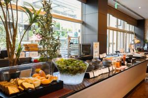 神戸市にあるKOKO HOTEL 神戸三宮のカウンターにパンと野菜が並んだビュッフェ