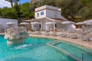 a swimming pool with chairs and a building at Atlantic Palace Hotel in Sorrento