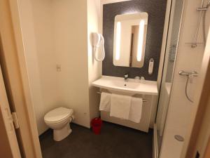 a bathroom with a sink and a toilet and a mirror at ibis Aurillac in Aurillac