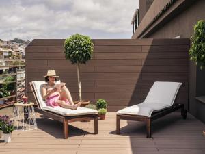 a woman sitting in a chair on a balcony at Mercure Barcelona Condor in Barcelona +93 photos