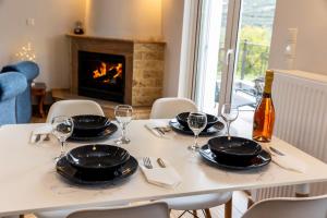 a table with plates and glasses and a bottle of wine at Thea Residence Kalavryta in Kalavrita