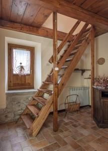 a wooden spiral staircase in a room with a window at Casa Tiglio in Pratovecchio