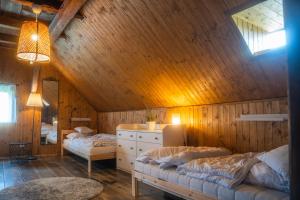1 dormitorio con 2 camas en una habitación de madera en Chalupa Císařský, en Šluknov 41 fotos más
