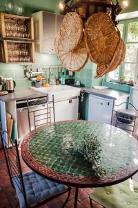 a kitchen with a glass table and some baskets at Domaine de Venoise, Château 31 personnes in Noyers-sur-Serein +35 photos