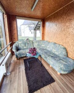 a living room with a couch and a table at Sodyba prie Mūšos 