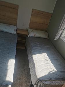 a bedroom with two beds and a window at Thornesbay holiday park in Isle of Wight