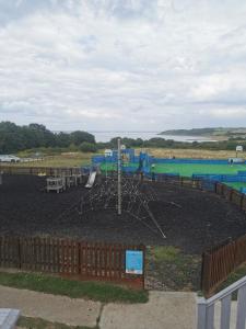 a park with a playground with a play equipment at Thornesbay holiday park in Isle of Wight