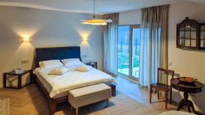 a bedroom with a large bed and a large window at Stone Nest in Călimăneşti