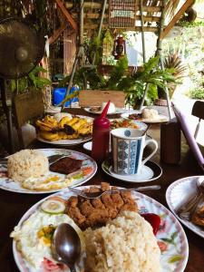 a table with many plates of food on it at Placido's Vacation Home in Puerto Galera
