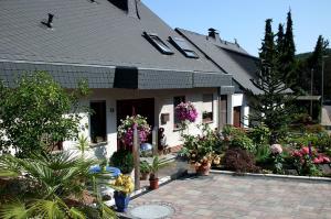 una casa con flores y plantas delante de ella en Gerä Umige Ferienwohnung In Lay Am Moselhang, en Coblenza