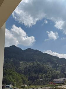 a view of a mountain with a blue sky and clouds at Khách sạn Giang Sơn Bắc Hà Lào Cai in Bắc Hà