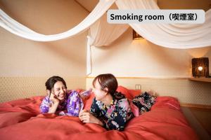 a man and a woman laying on a bed at Rurika in Izu