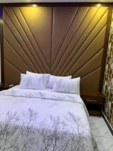 una habitación con una cama grande con sábanas y almohadas blancas en Defence Orchard DHA, en Dargai 20 fotos más