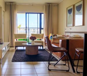 a living room with a table and chairs at Charming 2 Bedroom apartment in Ballito