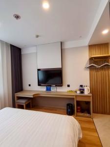 une chambre d'hôtel avec un lit et une télévision à écran plat dans l'établissement Beijing Northern Langyue Hotel Financial Street Branch, à Pékin