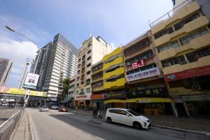 a white car parked on a city street with buildings at Hotel Bintang Kuala Lumpur in Kuala Lumpur