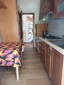a kitchen with wooden cabinets and a table with a pattern at Desiree Holiday Inn in Le Grazie