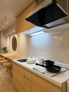une cuisine avec un évier et une cuisinière four supérieur dans l'établissement Clio Matoba by b hotel - Fully Equipped Urban Studio Peaceful Stay, à Ōsukachō 30 autres photos