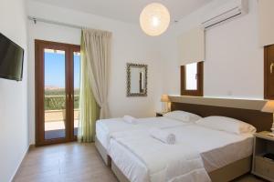 a bedroom with a large bed and a balcony at Kampos Villa 1 in Achlades