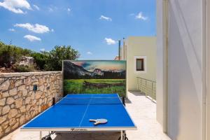 a blue ping pong table in front of a painting at Kampos Villa 1 in Achlades