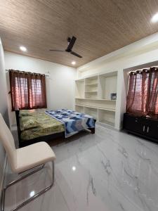 Cette chambre comprend un lit et une chaise. dans l'établissement Casa Bianca Penthouse Retreat, à Secunderābād
