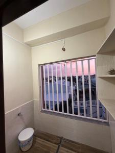 La salle de bains est pourvue de toilettes et d'une grande fenêtre. dans l'établissement Casa Bianca Penthouse Retreat, à Secunderābād 29 autres photos