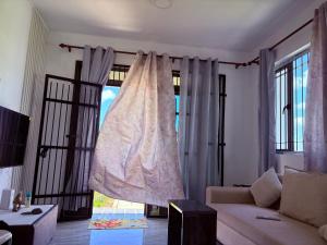 Una sala de estar con un sofá y una ventana. en Cool Breeze Villa No 2, en Grand Baie