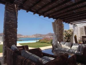 a patio with wicker furniture and a view of the water at Naousa in Naousa