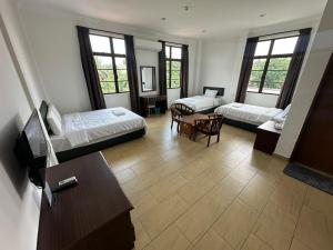 una sala de estar con dos camas y una mesa en Glistar Hotel, en Tampin