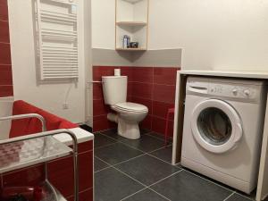 a bathroom with a toilet and a washing machine at T2 avec vue sur les montagnes et wifi in Le Lioran +34 photos