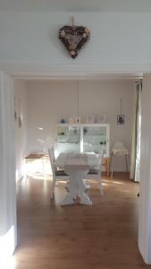 Un comedor blanco con una mesa y sillas. en Ferienwohnung Hunteblick, en Wildeshausen
