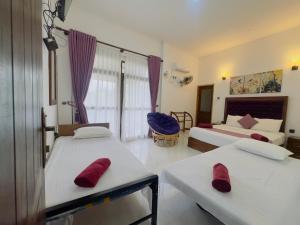 une chambre avec deux lits et un canapé dans l'établissement Heaven Breeze, à Kandy