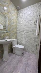 a bathroom with a toilet and a sink and a shower at Art Dream Hotel in Tashkent