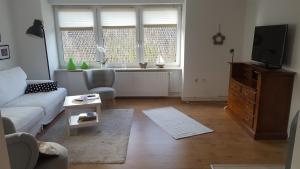 a living room with a couch and a tv at FerienwohnungHunteblick in Wildeshausen