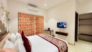 乌代浦MAYA'S MANOR - A Luxury Lake View Boutique Hotel的一间带床和电视的酒店房间