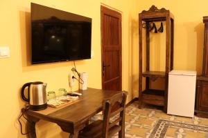 een kamer met een houten tafel en een televisie aan de muur bij Katmani Hotel in Mardin