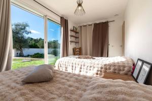 a bedroom with two beds and a large window at Villa Valle Pace Maria - Piscine Privée in Afa +17 photos